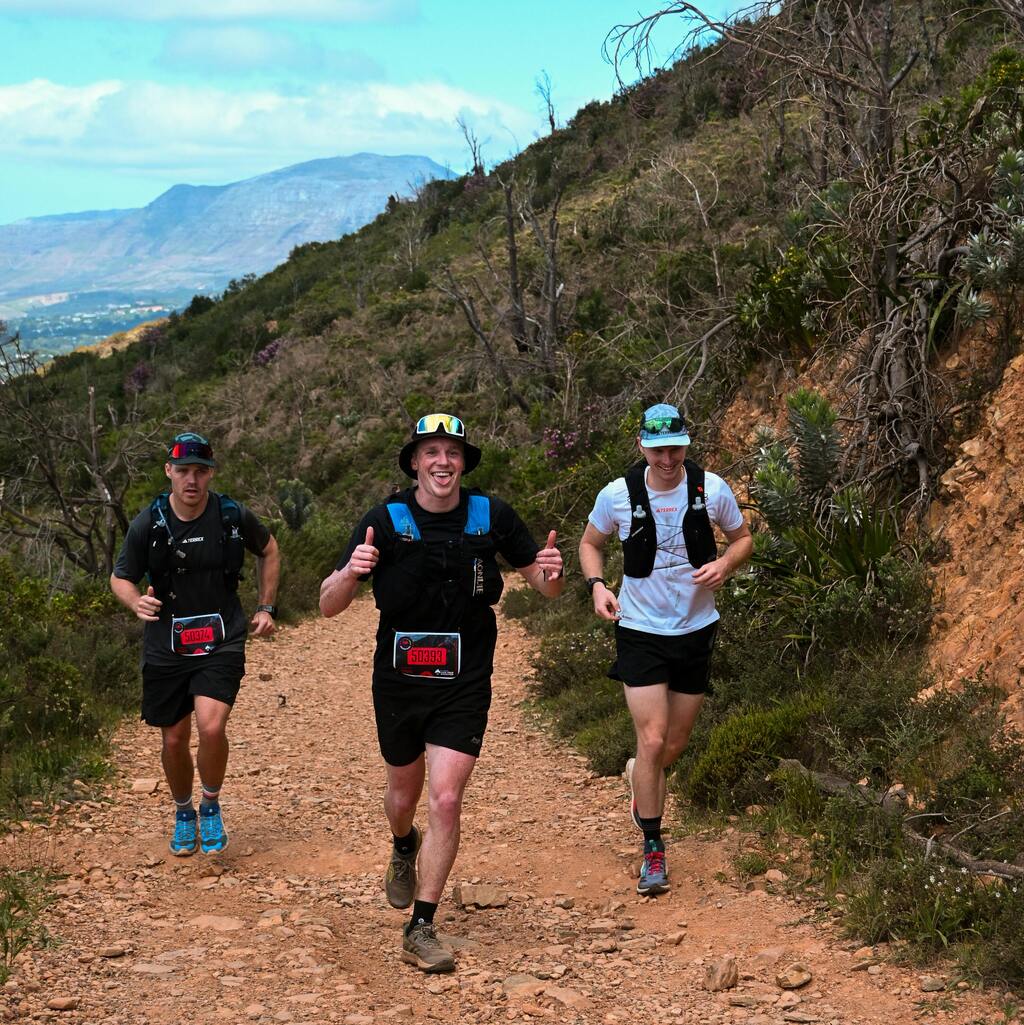 Group of trail runners enjoying a sunny day on a rugged path in Cape Town South Africa.