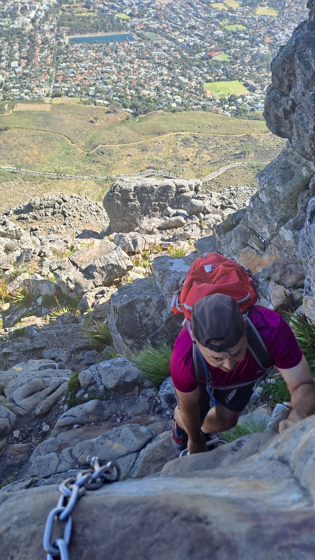 A man using the chains on India Venster hiking trail.